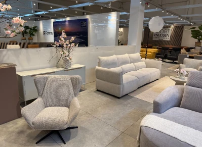 Furniture showroom with white armchairs and a floral display