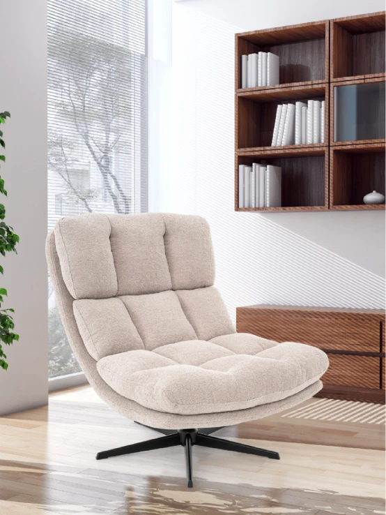 Cream bouclé swivel lounge chair in front of a bookshelf