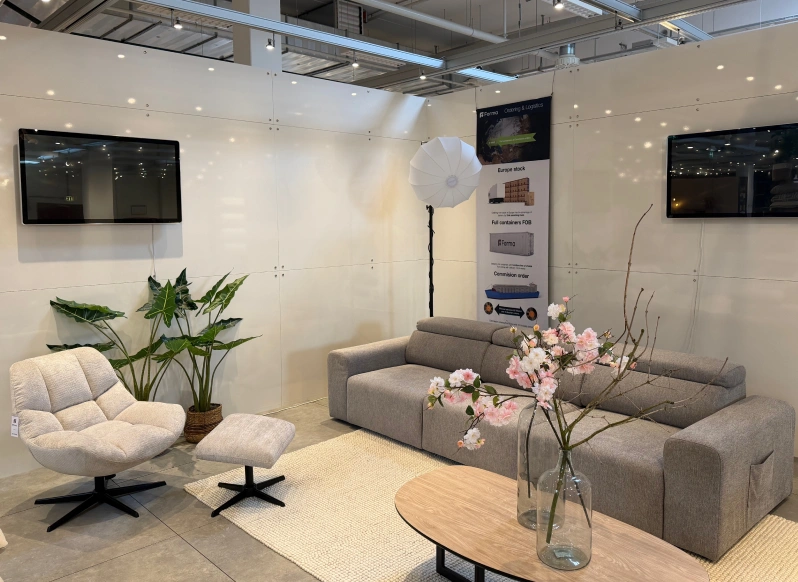 Furniture showroom with a grey sofa, plants and display screens